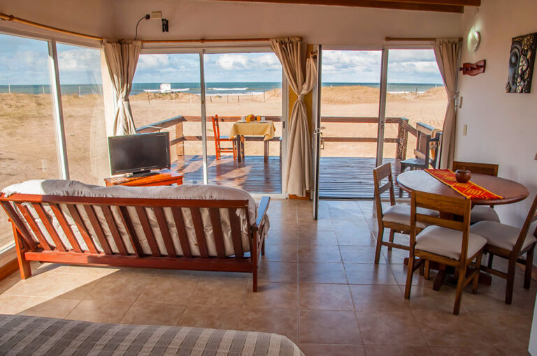 Playa Loft: estar y comedor con salida al deck frente a la playa