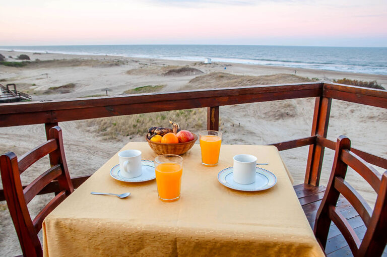 Duplex 3: mesa en el deck con vista al mar al atardecer