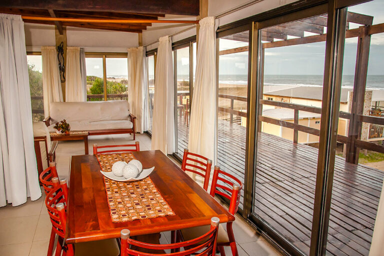 Casa Norte o Sur: mesa del comedor y deck con vista al mar