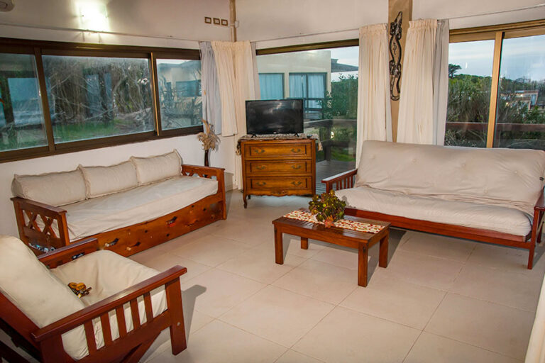 Casa Norte o Sur: living con sillones y vista al bosque