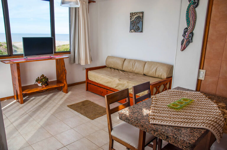Sol G y E: mesa del comedor y sillón con vista al mar