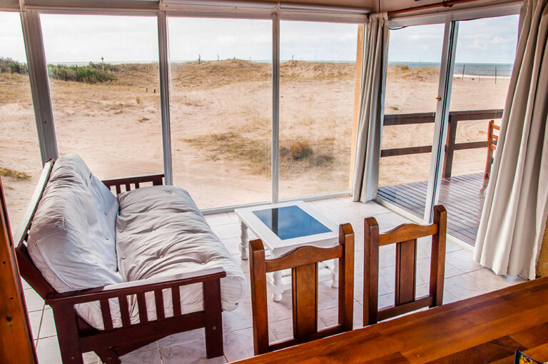 Playa Loft: futón y mesa frente al ventanal a la playa