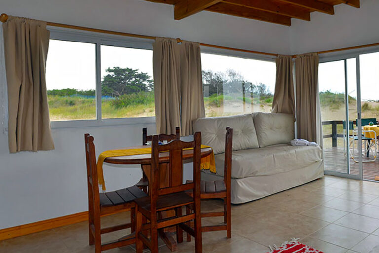 Playa 2 ambientes: comedor y sillón frente a los ventanales